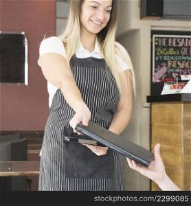 smiling waitress giving menu customer restaurant