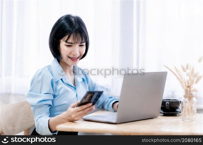 Smiling with dental braces asian freelance people Businesswoman writing message on smartphone casual working with laptop computer with a coffee cup mug at the cafe,Business Lifestyle