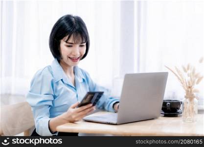 Smiling with dental braces asian freelance people Businesswoman writing message on smartphone casual working with laptop computer with a coffee cup mug at the cafe,Business Lifestyle