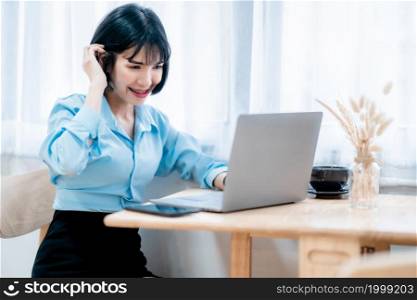 Smiling with dental braces of asian freelance people business female casual working with laptop computer and notebook with coffee cup and smartphone in cafe interior in coffee shop