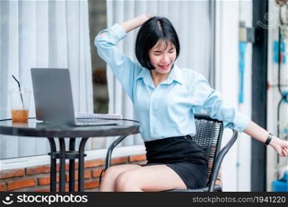 Smiling with dental braces Stretching Relaxation Resting of asian freelance people business female casual working with laptop computer with coffee cup and smartphone in coffee shop the background