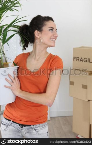 Smiling woman carrying a plant