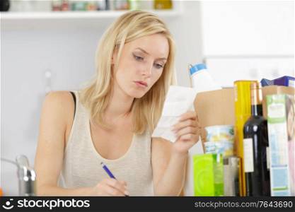 smiling woman checking recipe at home