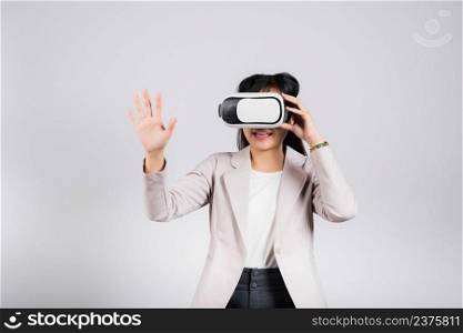 Smiling woman confidence excited wear VR headset device touching air during virtual reality experience isolated white background, Asian happy portrait female playing video game studio shot, copy space