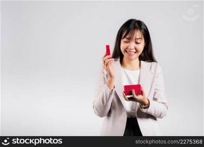 Smiling woman confidence opening a red gift box on palm isolated white background, surprise birthday or Christmas day and valentine, Asian happy portrait beautiful young female studio shot, copy space