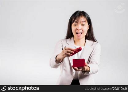 Smiling woman confidence opening a red gift box on palm isolated white background, surprise birthday or Christmas day and valentine, Asian happy portrait beautiful young female studio shot, copy space