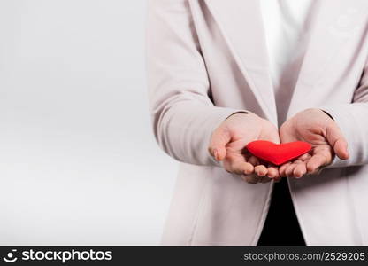 Smiling woman confidence showing holding red heart with her hand palm isolated white background, Asian happy portrait beautiful young female send love and happy valentine in studio shot, copy space