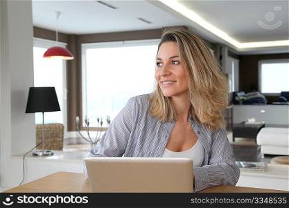 Smiling woman connected on internet at home