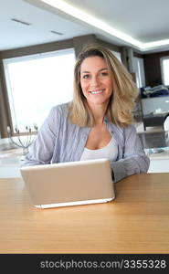 Smiling woman connected on internet at home