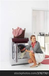 smiling woman dooing laundry with washing machine