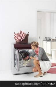 smiling woman dooing laundry with washing machine