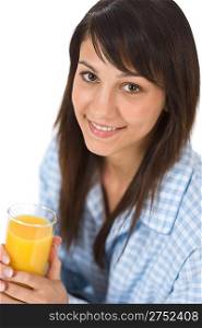 Smiling woman drink orange juice in pajamas for breakfast on white background