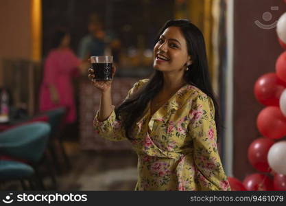 Smiling woman drinking coke at restaurant