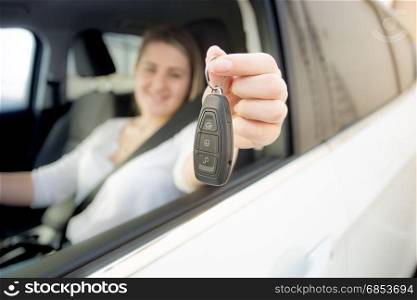 Smiling woman driving a car holding car keys