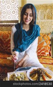 smiling woman eating arab restaurant