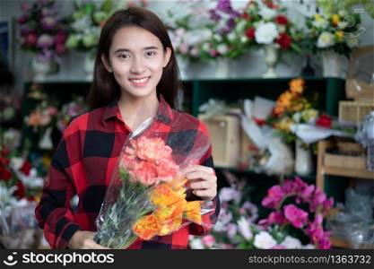 Smiling woman florist small business flower shop owner and Young florist examining flowers at the shop