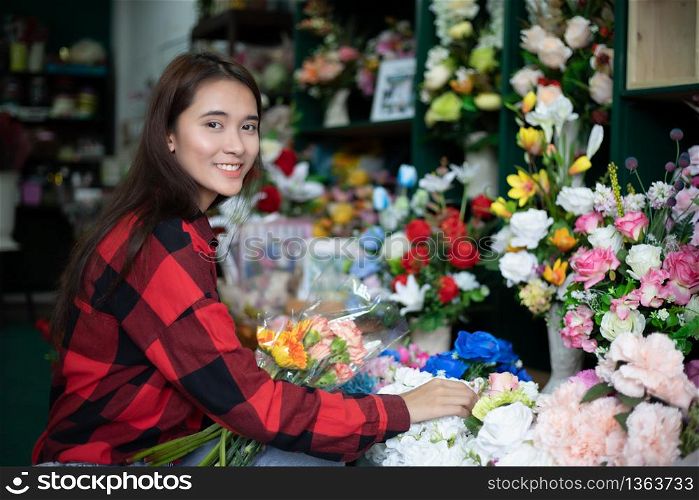 Smiling woman florist small business flower shop owner and Young florist examining flowers at the shop