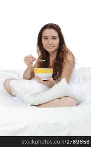 smiling woman having breakfast sitting on her bed at home. Isolated on white background