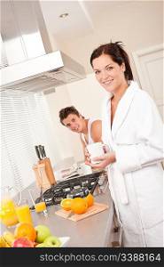 Smiling woman having coffee for breakfast in the kitchen