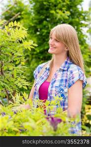 Smiling woman hold tree plant at garden centre shopping
