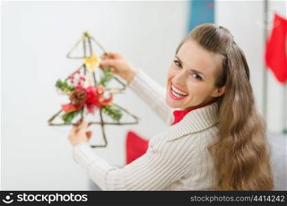 Smiling woman holding Christmas decoration tree