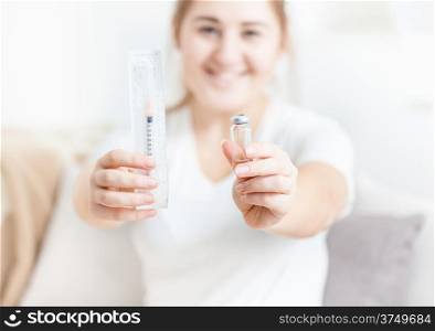Smiling woman holding insulin syringe