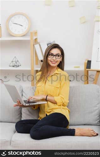 smiling woman holding laptop looking away