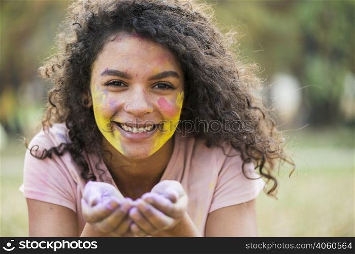 smiling woman holding powdered paint her hands