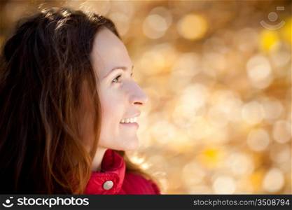 Smiling woman in autumn park against leaves background