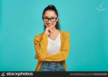 Smiling woman in glasses, blue background, positive emotion. Face expression, female person looking on camera in studio, emotional concept, feelings. Smiling woman in glasses, positive emotion