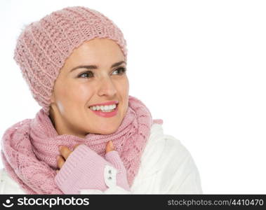 Smiling woman in knit scarf, hat and mittens looking on copy space