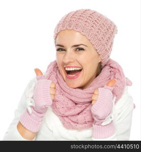 Smiling woman in knit scarf, hat and mittens showing thumbs up