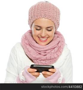 Smiling woman in knit winter clothing writing text message