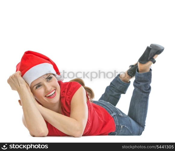 Smiling woman in Santa hat laying on floor and looking on copy space