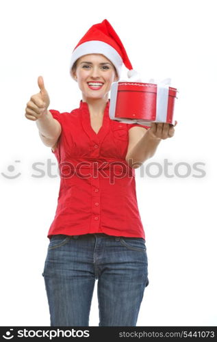 Smiling woman in Santa hat with Christmas present box showing thumbs up