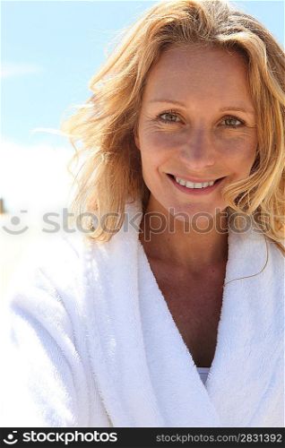 Smiling woman in toweling robe outdoors