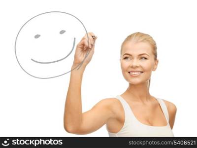 smiling woman in white shirt drawing happy smile on glass