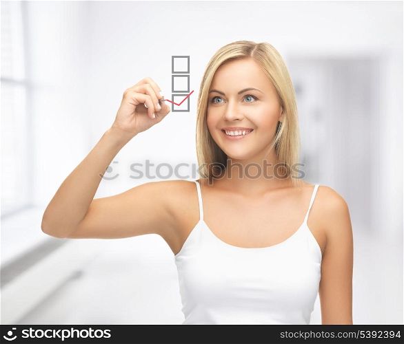 smiling woman in white shirt drawing red checkmark into checkbox