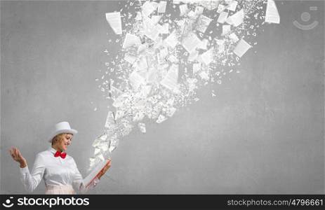 Smiling woman looking in book. Young woman in white hat with opened red book in hands