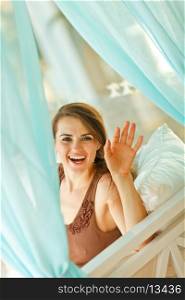 Smiling woman looking out from curtain&#xA;
