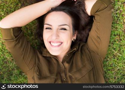Smiling woman lying and relaxing in grass