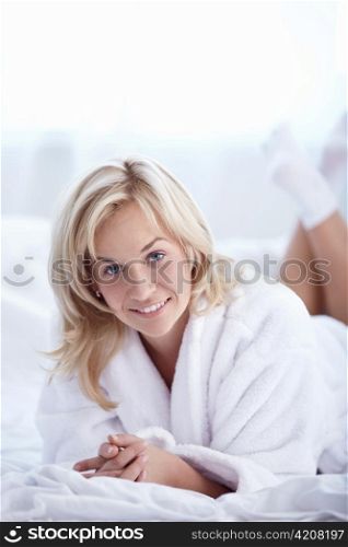 Smiling woman lying on a bed