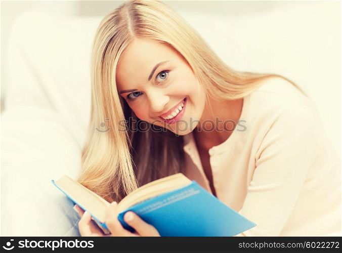 smiling woman lying on the sofa and reading book. woman reading book