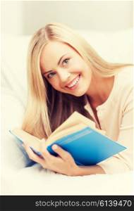smiling woman lying on the sofa and reading book. woman reading book
