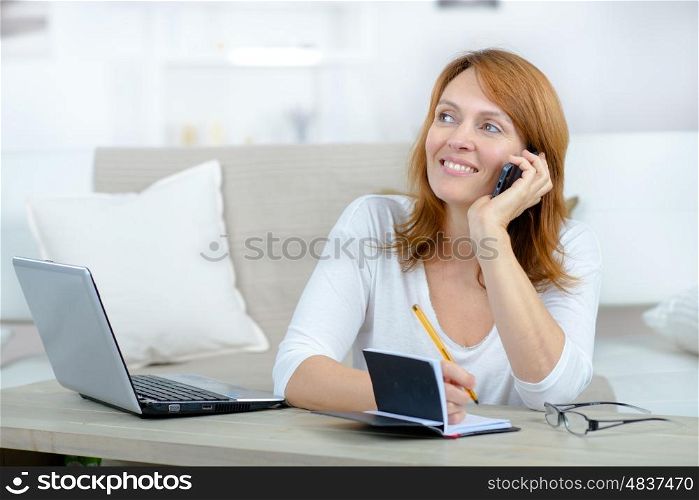 smiling woman making an appointment in a diary