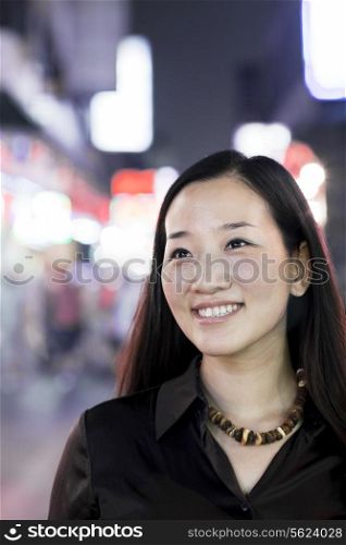 Smiling woman out at night in the city, portrait