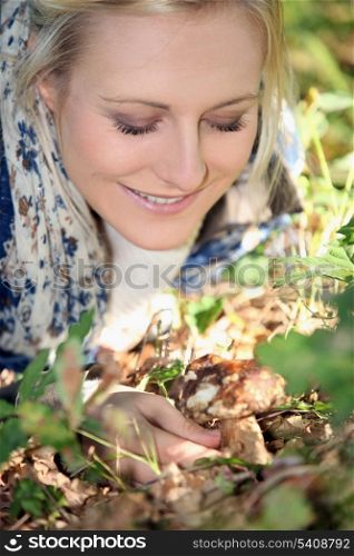 Smiling woman picking mushrooms