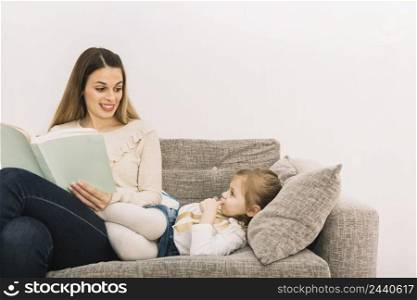 smiling woman reading fairy tale daughter