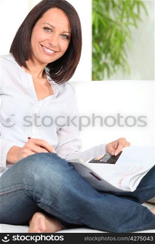 Smiling woman reading magazine