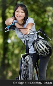 smiling woman rider posing with mountain bicycle